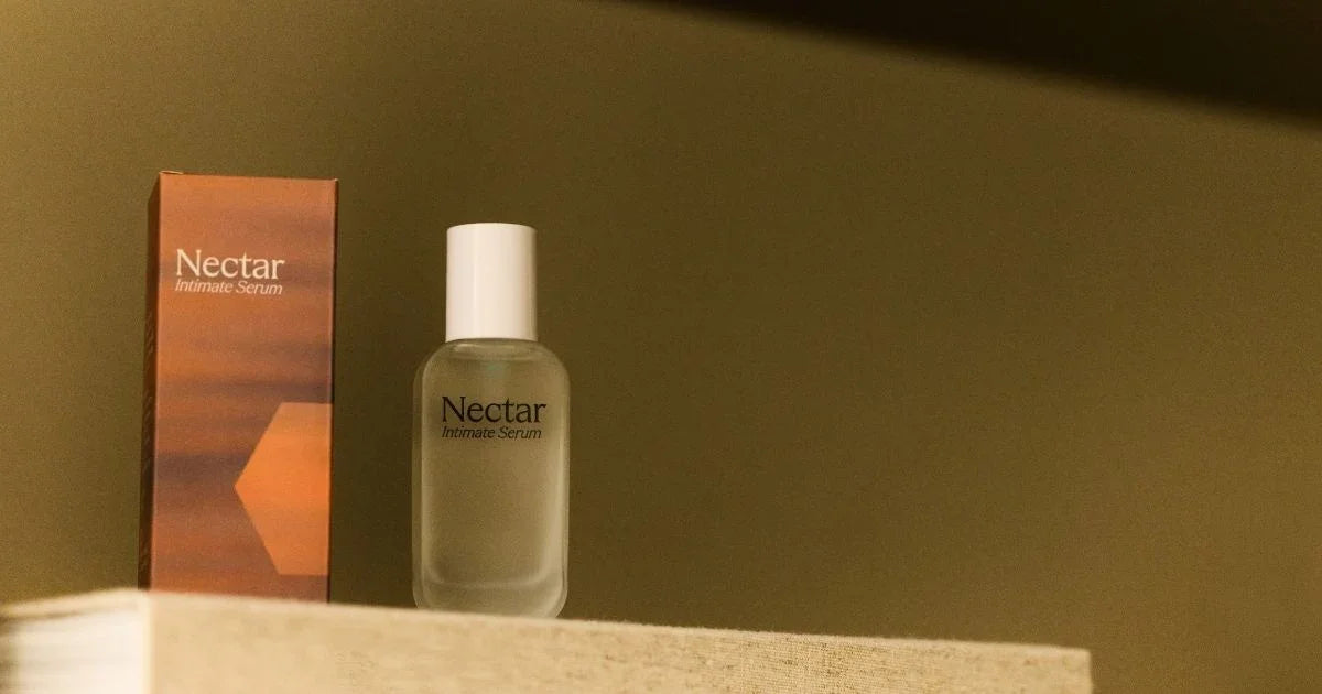 Nectar intimate serum product packaging on a wooden surface with a blurred background